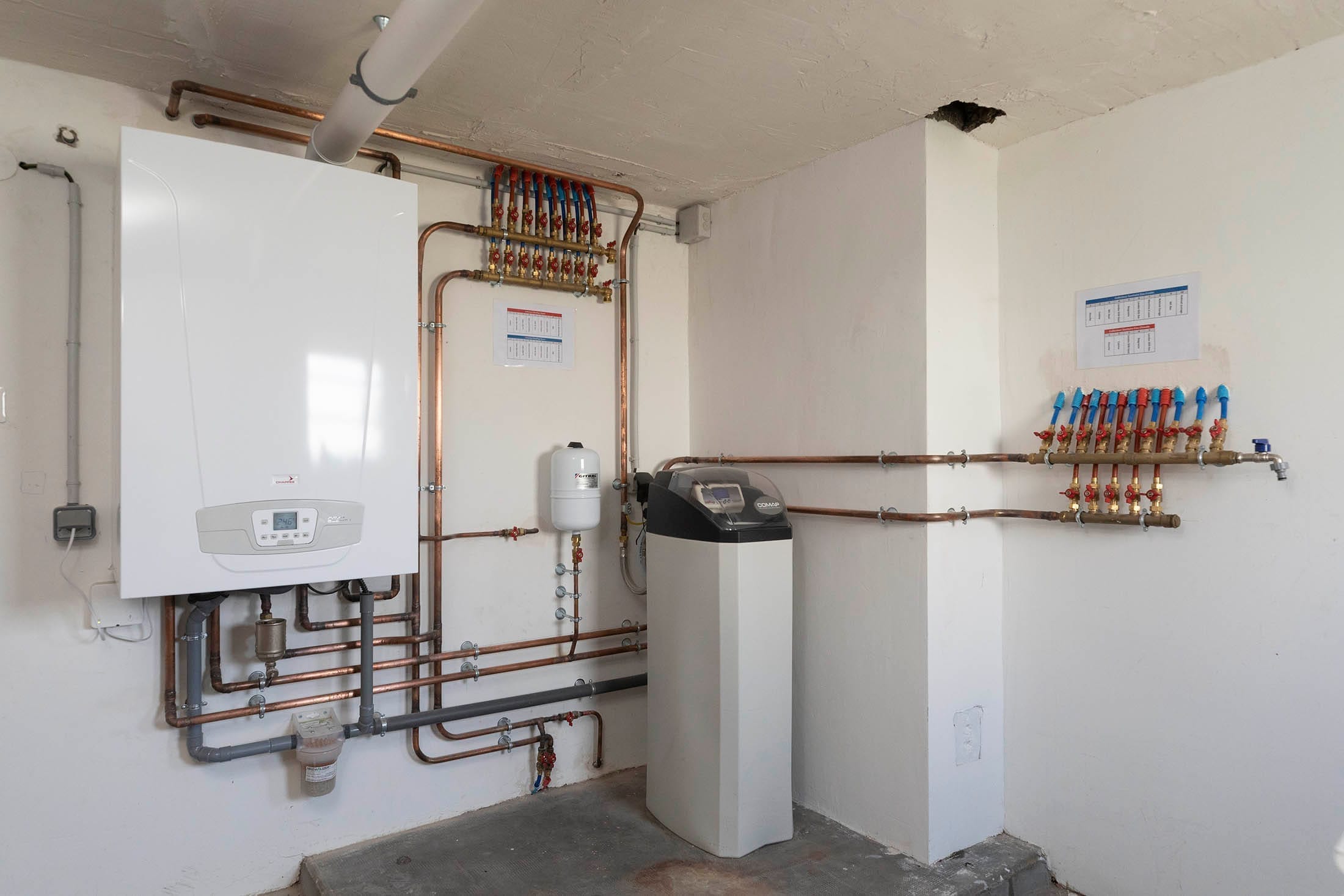 Salle technique avec chaudière, adoucisseur et collecteurs — installation réalisée par Yce Confort