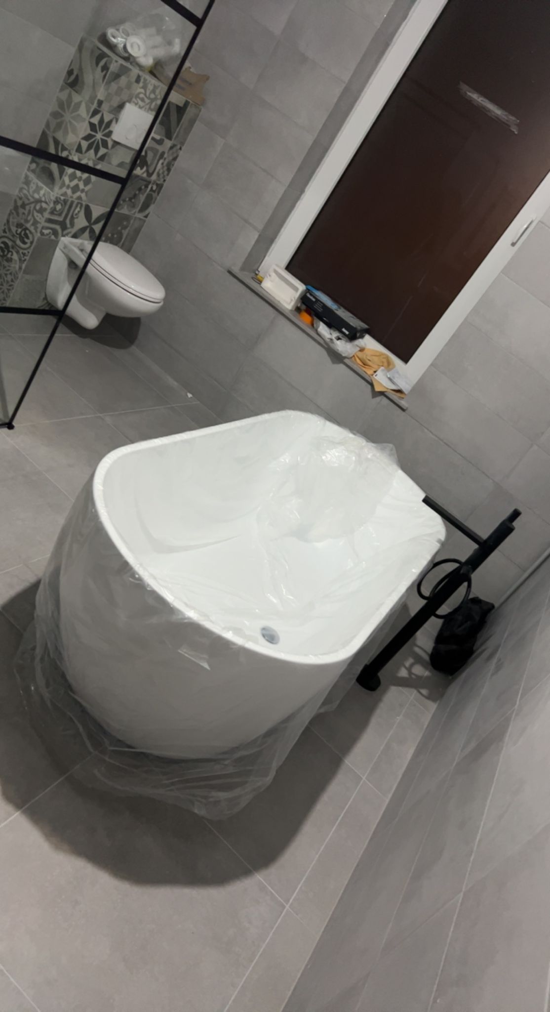 Baignoire îlot installée avec robinetterie noire